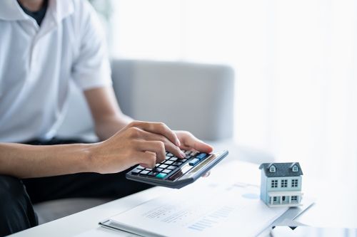 Foto: Mann tippt auf Taschenrechner